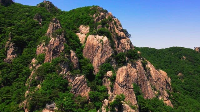 Lush green rocky mountains under clear skies