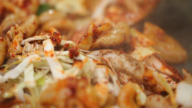 Stir-fried gopchang with vegetables on a hot plate