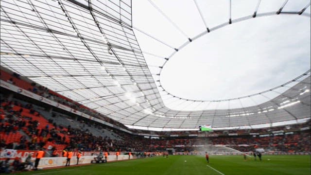 Crowded sports stadium with soccer game on a cloudy day