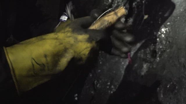 Worker placing explosive charges in a coal mine