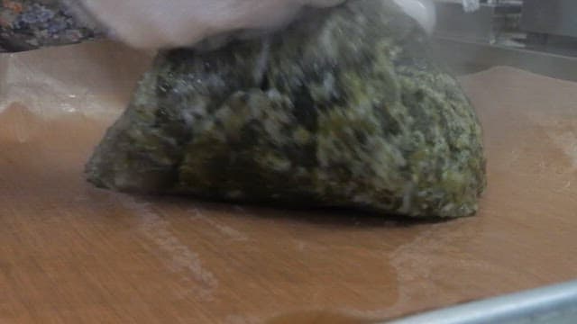 Hands mixing steaming mugwort rice cake dough