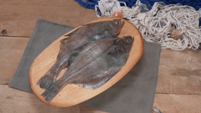 Plate of fresh fish on a wooden table