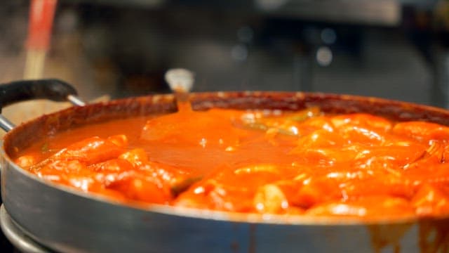Tteokbokki simmering in a large pan