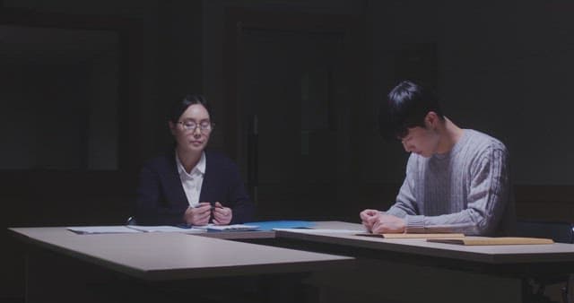 Man and a woman confronting each other over documents in a dark room