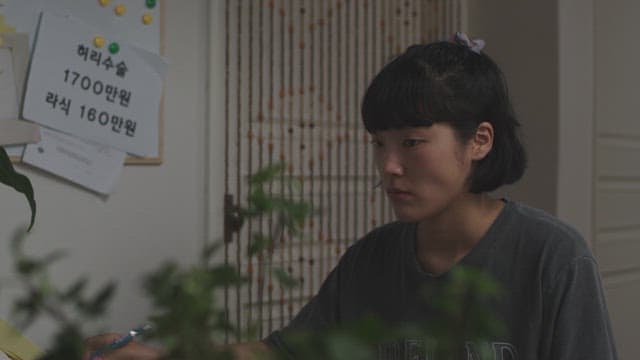 Pensive woman holding a pen in a dark room