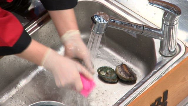 Cleaning abalone under running water