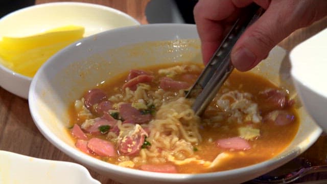 Ramyeon with sausages being served