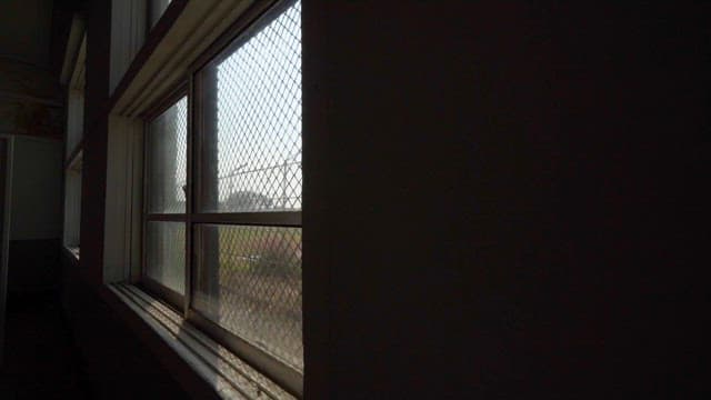 Sunlight Through a Window Surrounded by Barbed Wire