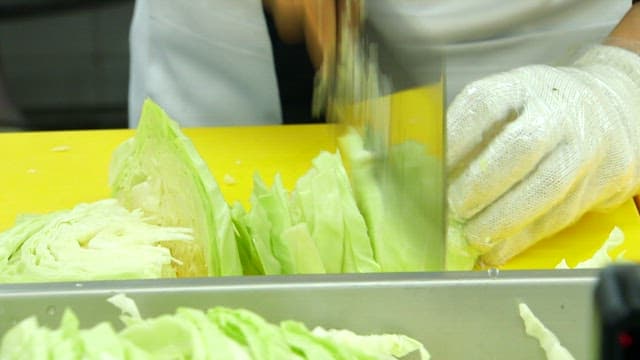 Chopping cabbage on a yellow cutting board