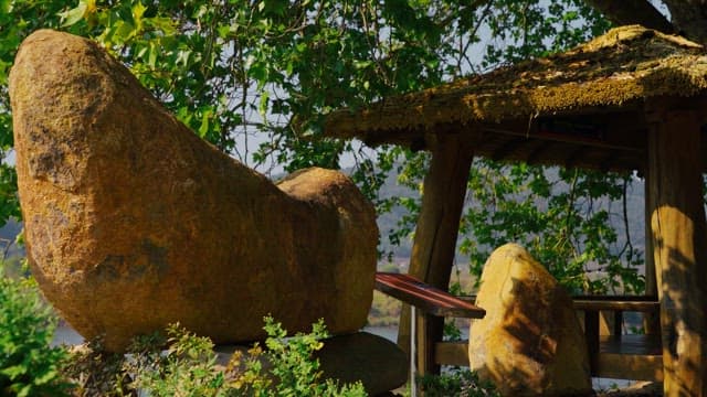 Rock tower surrounded by trees and greenery