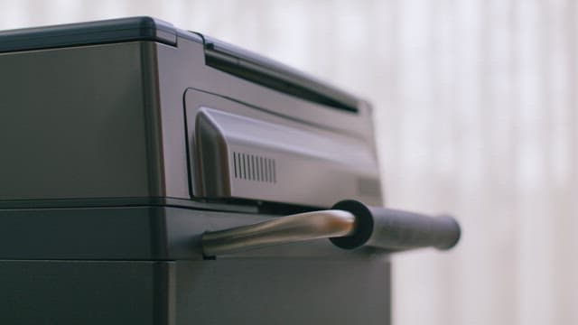 Person in Yellow Clothes Pushing a Trolley Handle