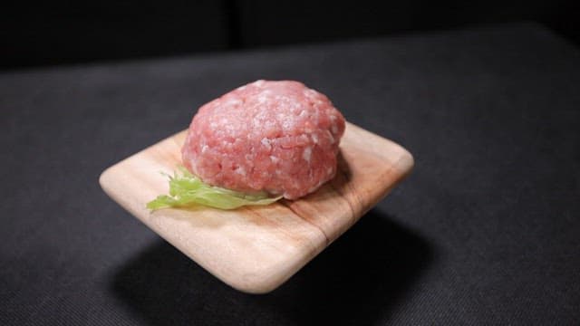Wooden plate with raw minced meat and Chinese meat noodles