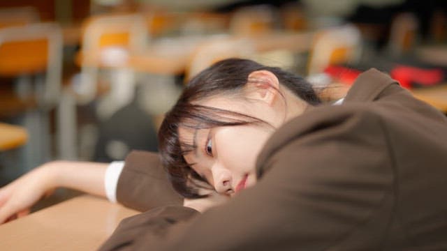 Student resting at a classroom desk