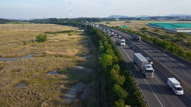Highway with vehicles and surrounding fields
