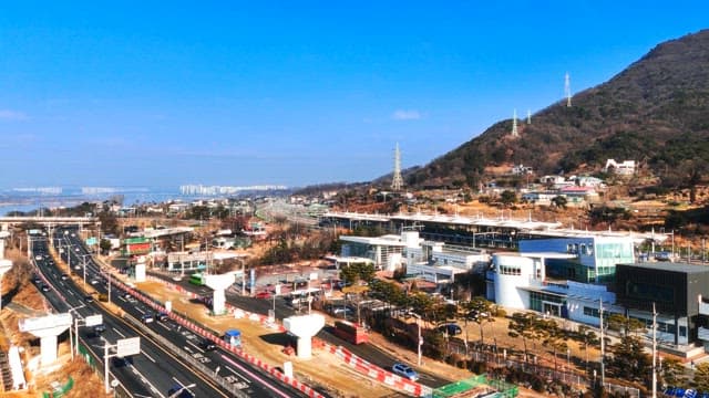 City Traffic and Buildings Located at the Foot of a Mountain