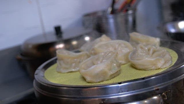 Steamed dumplings being prepared in a kitchen
