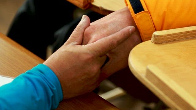 Two People Holding Hands Across a Desk