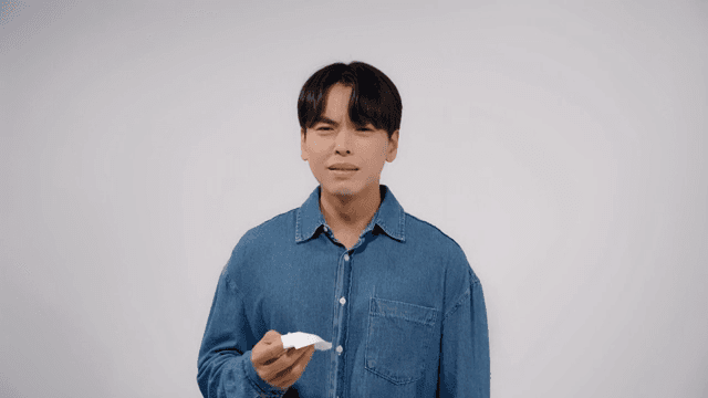 Man in a denim shirt crying while looking straight ahead with a serious expression