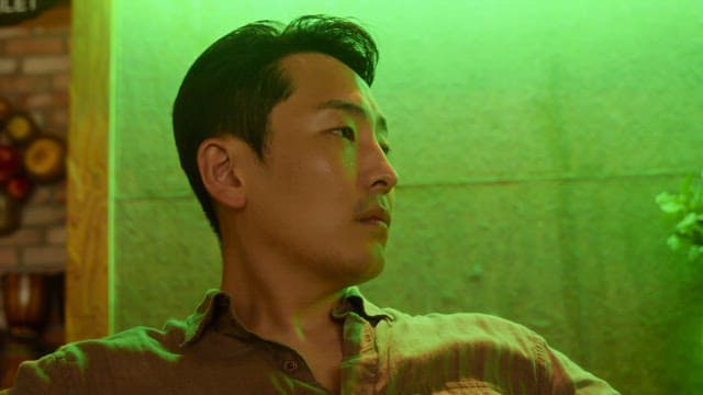 Man looking around in green light indoors