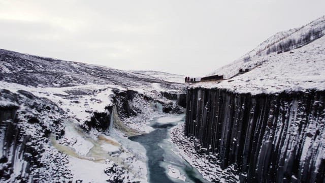 Snow-covered canyon with icy river