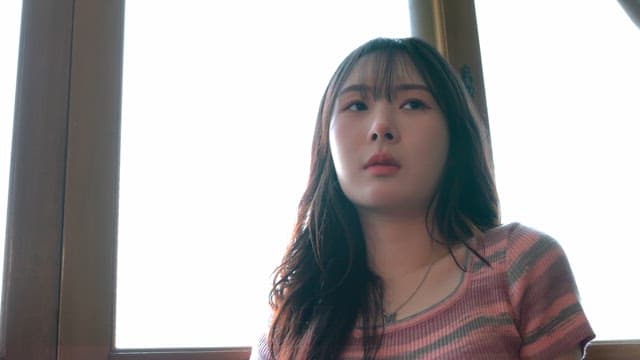 Woman sitting by a window in thought