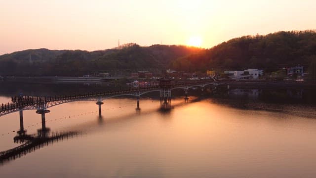Scenic bridge over a calm river at sunset