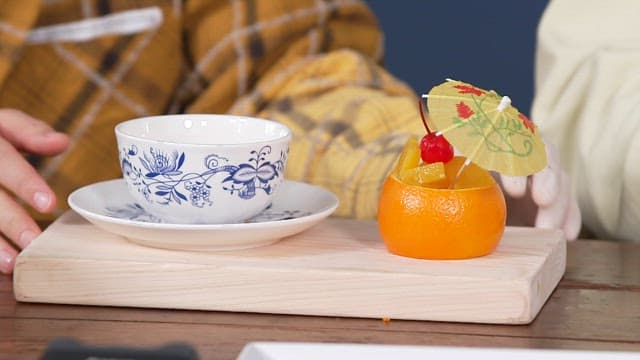 Refreshing fruit dessert and warm tea poured into a porcelain teacup