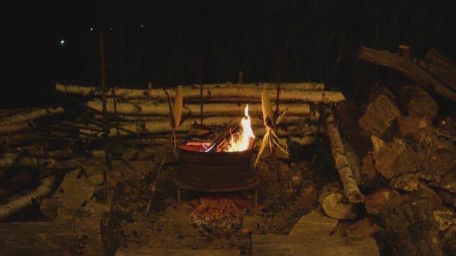 Corn roasting over a campfire at night
