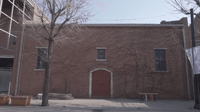 Vines crawling over a red door on a brick building