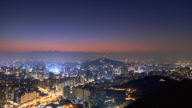 Cityscape of a vibrant metropolis at dawn with a colorful horizon