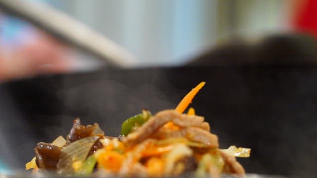 Stir-fried vegetables and meat in a wok
