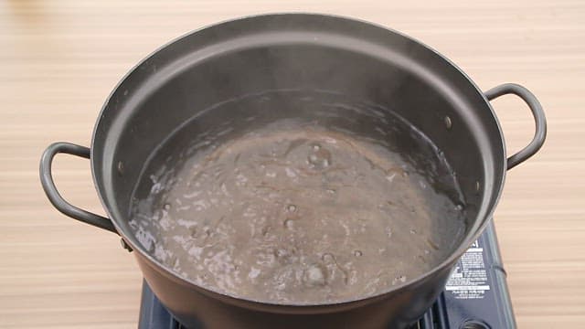 Boiling dried radish greens in a pot on a stove