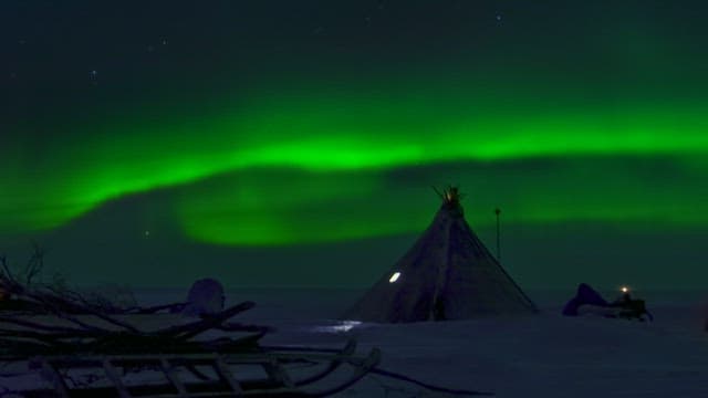 Aurora over a snowy traditional village