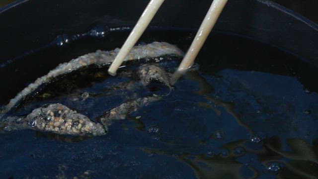 Frying laver chip in hot oil with chopsticks