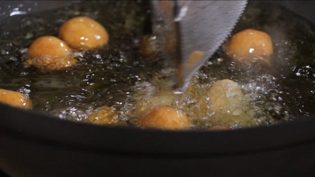 Golden brown doughnuts frying in oil