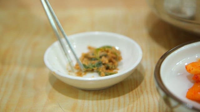 Spoonful of rice served with green chili peppers in soybean paste and sujebi soup
