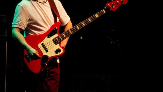 Musician with bass guitar getting into the rhythm on stage