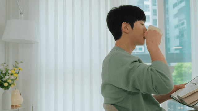 Man Reading a Book While Drinking Coffee