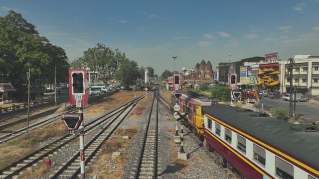 Train Moving through a Residential Area with Surrounding Greenery and Buildings