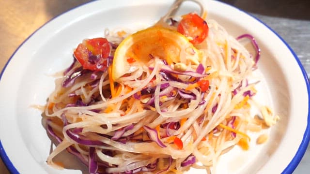 Preparing a Vibrant Thai Food Garnished with Peanuts and Fresh Cilantro