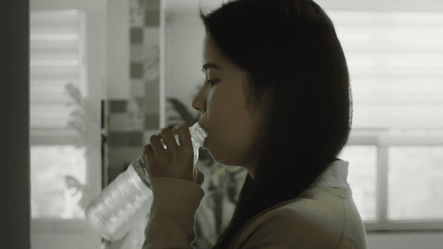 Woman seeing drinking water in a kitchen