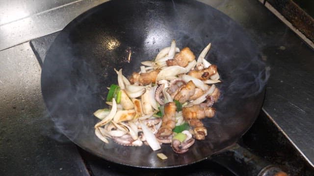 Chef Cooking Spicy Stir-fried Webfoot Octopus with a Wok