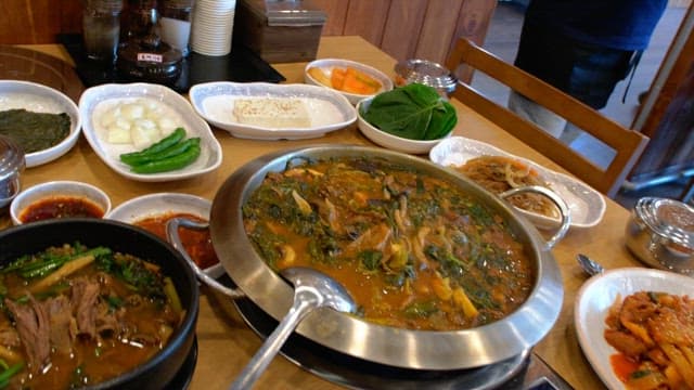 Table in a restaurant with a variety of food and side dishes