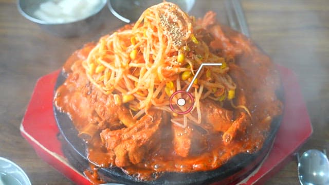 Spicy braised pork ribs with steam rising from the bottom