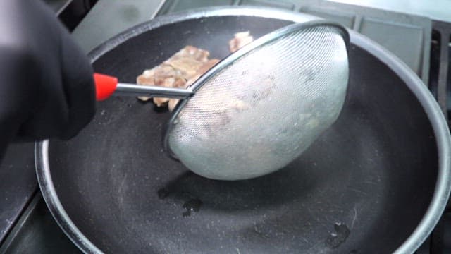 Oxtail cooked in a pan in a restaurant kitchen