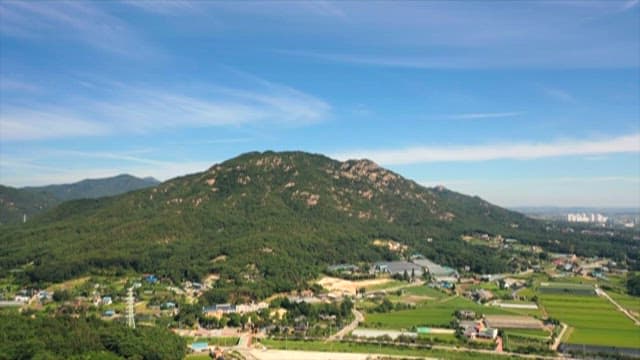 Lush Green Landscape with Mountains and Fields