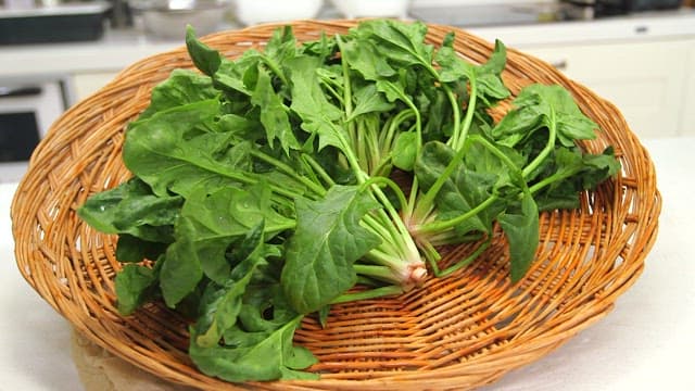 Fresh spinach in a wicker basket