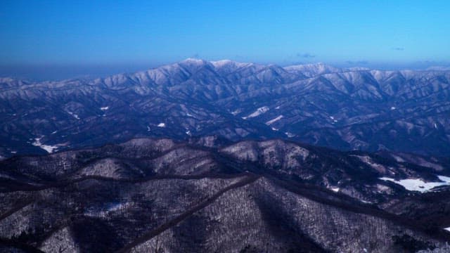 Valley of magnificent snow-covered mountains under a clear blue sky