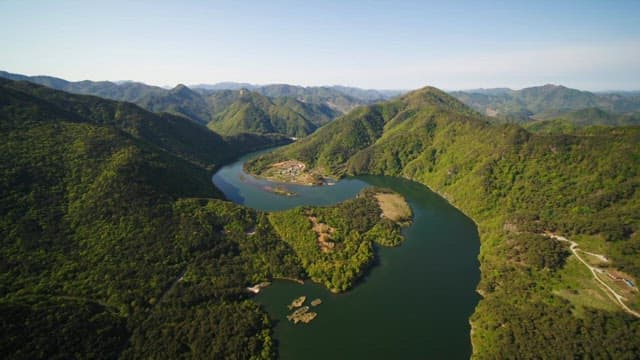 Serene river winding through lush green mountains