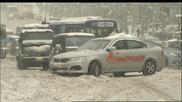 Snow-covered streets with stuck vehicles